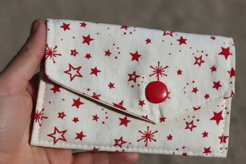 Small fabric pouch with red star pattern on a dark background